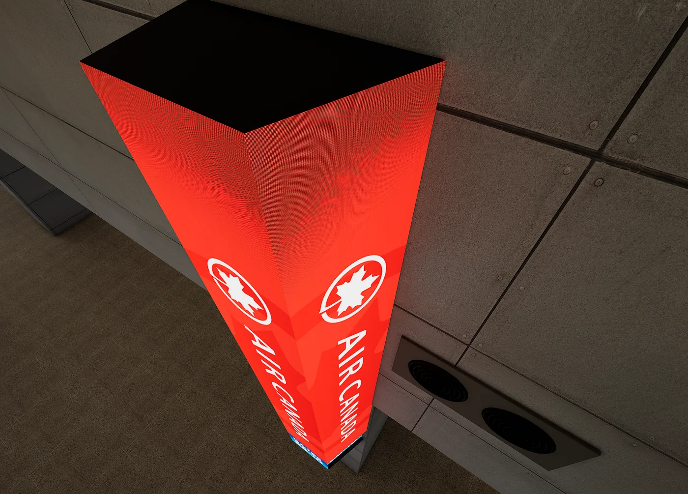 An LED identity column seen from above, carrying artwork on both faces with a dark cap across the top