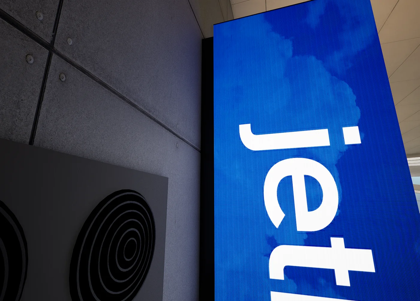 A close view of an LED identity column showing the pixel structure of the panel behind the airline artwork